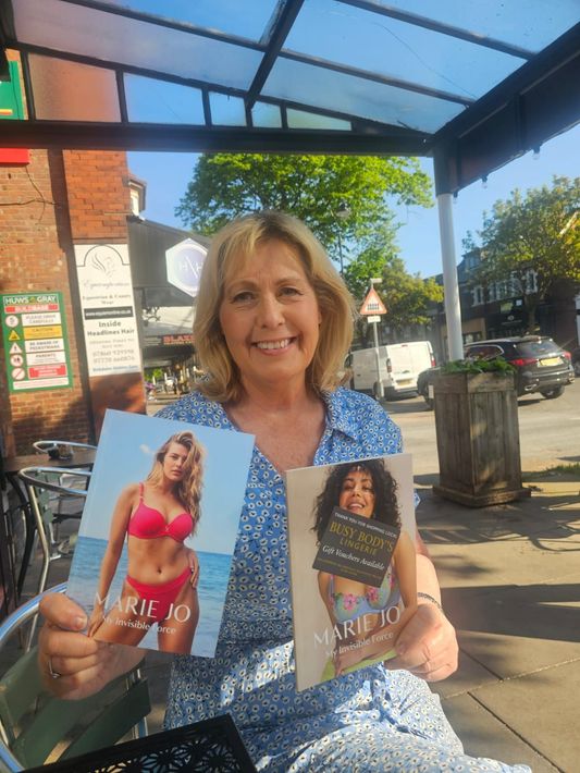 Jan Morton is holding two books in her hands and smiling.