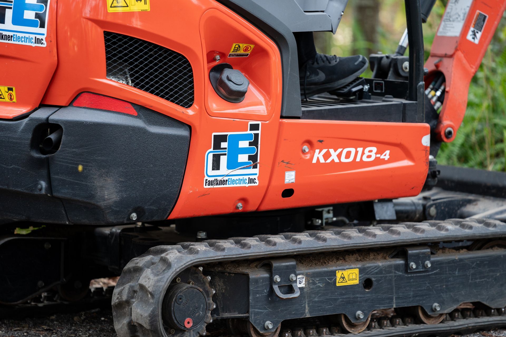 Our orange mini excavator with the Faulkner Electric logo on it ready to go on the jobsite