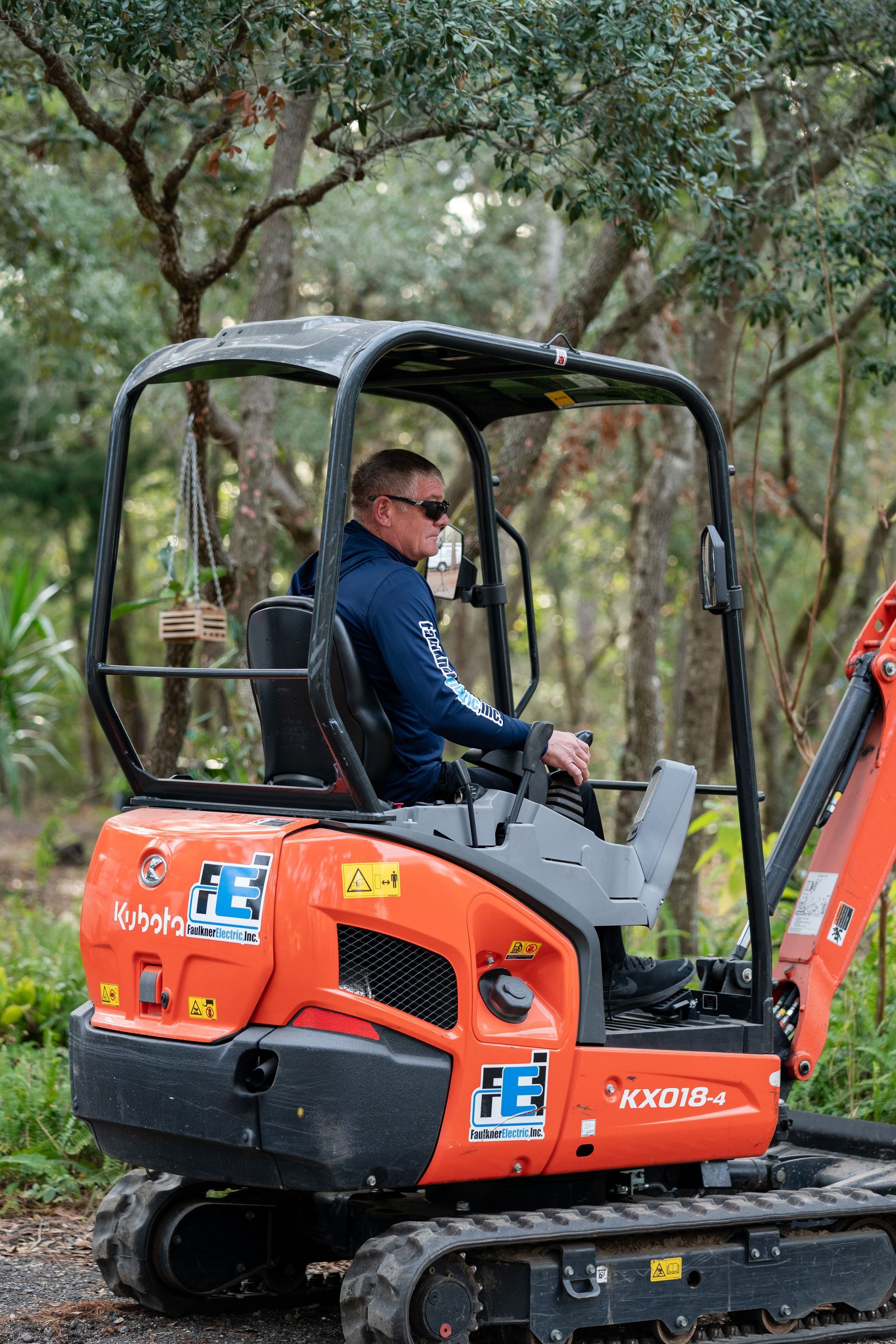 Faulkner Electric employee on our mini excavator to dig large trench for underground cabling