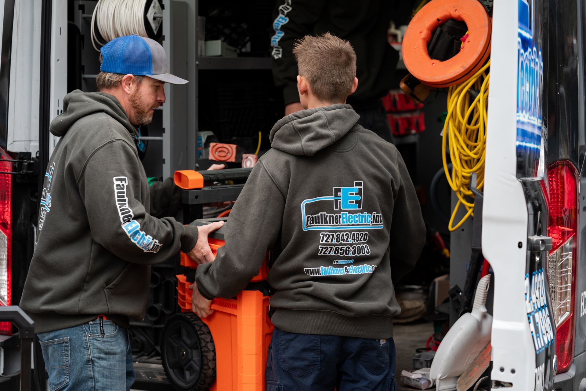 two of our skilled electricians unloading electrical parts from the van for a repair call