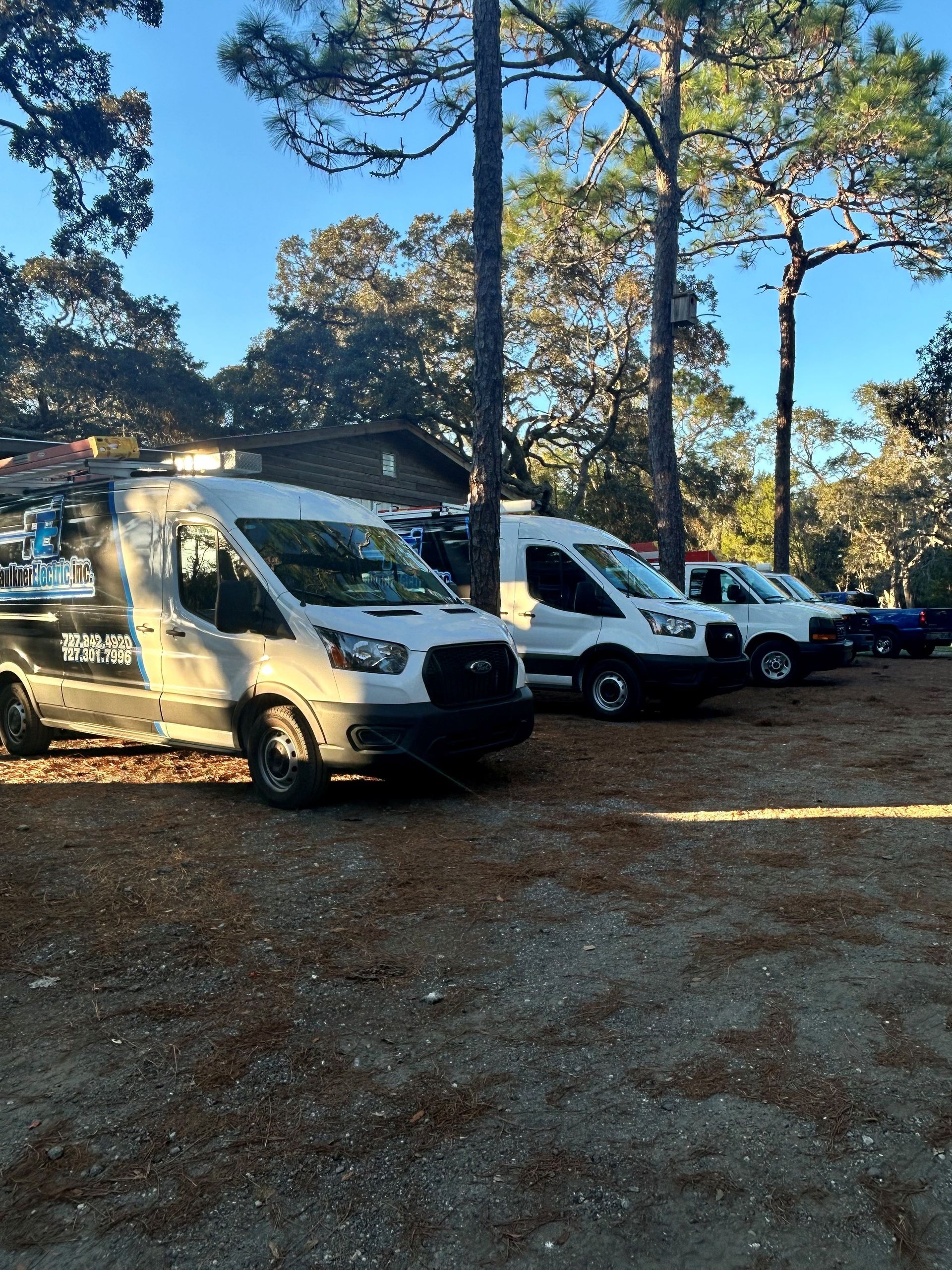 Several of our Electric work vans lined up on a job site