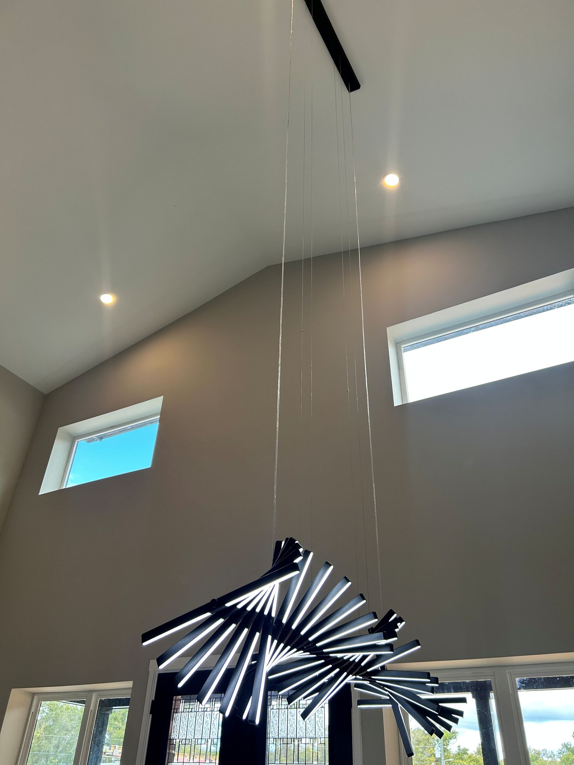 Custom art chandelier hanging down from the foyeur with new recess lights by Faulkner Electric to illuminate it.