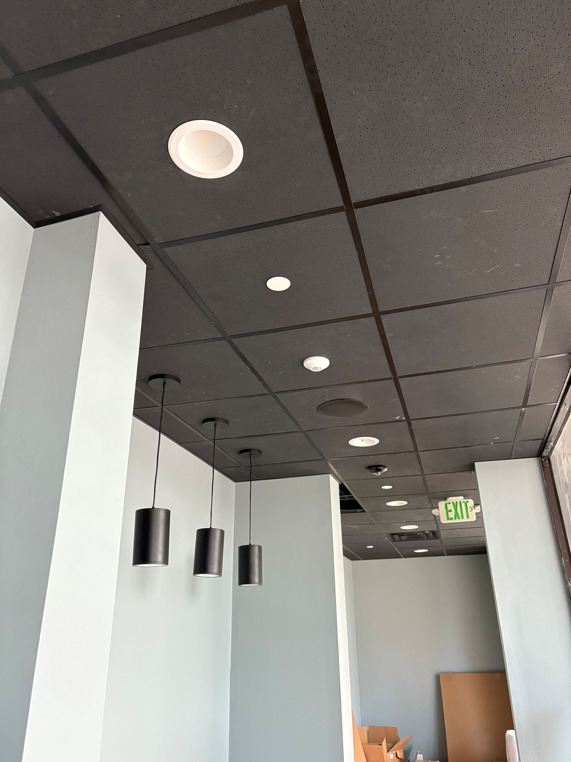 Finished recess lighting for commercial property, white recess lights on a black tiled ceiling