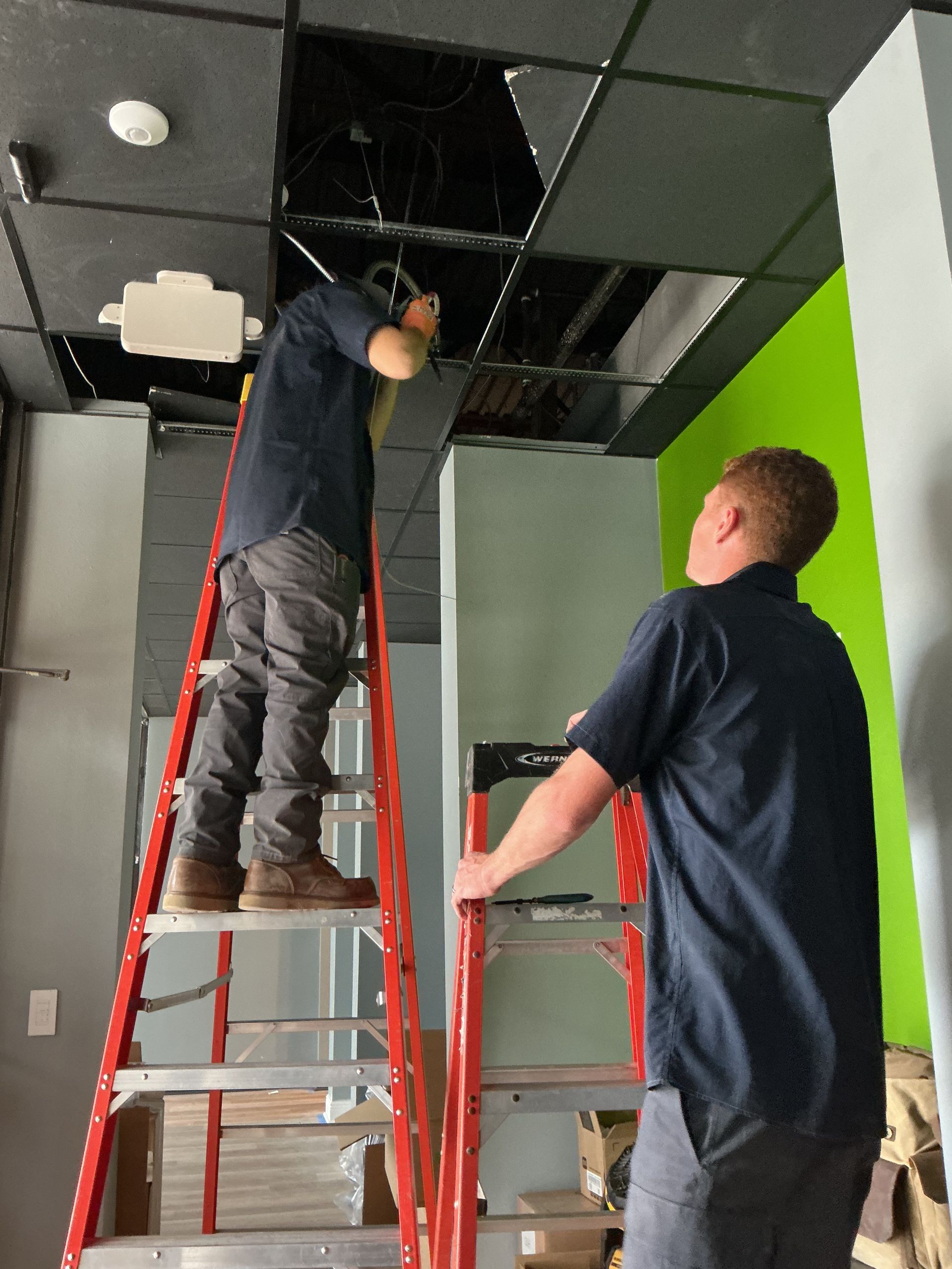 Two of our electricians hard at work for a commercial job requiring ceiling cabling