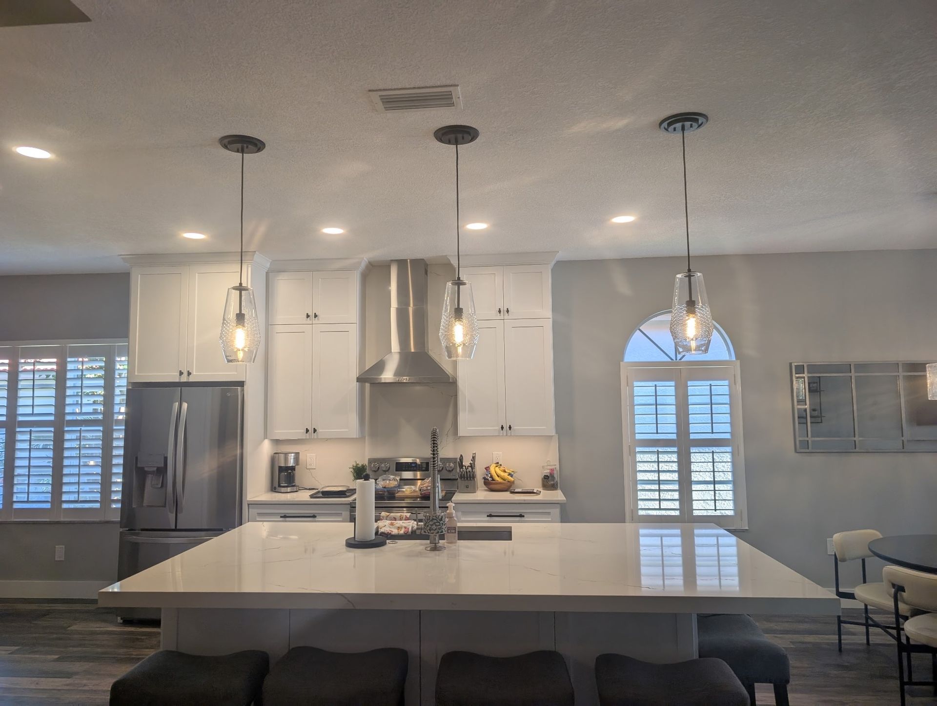 Brightly lit kitchen with both recess lights and hanging lights installed residentially in Spring Hill, FL