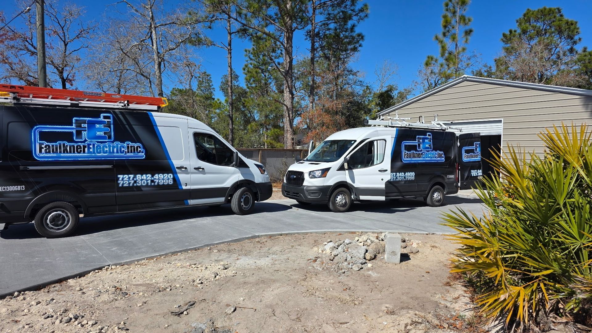 Faulkner Electric work vans on the driveway of a residential job in Wesley Chapel, Florida