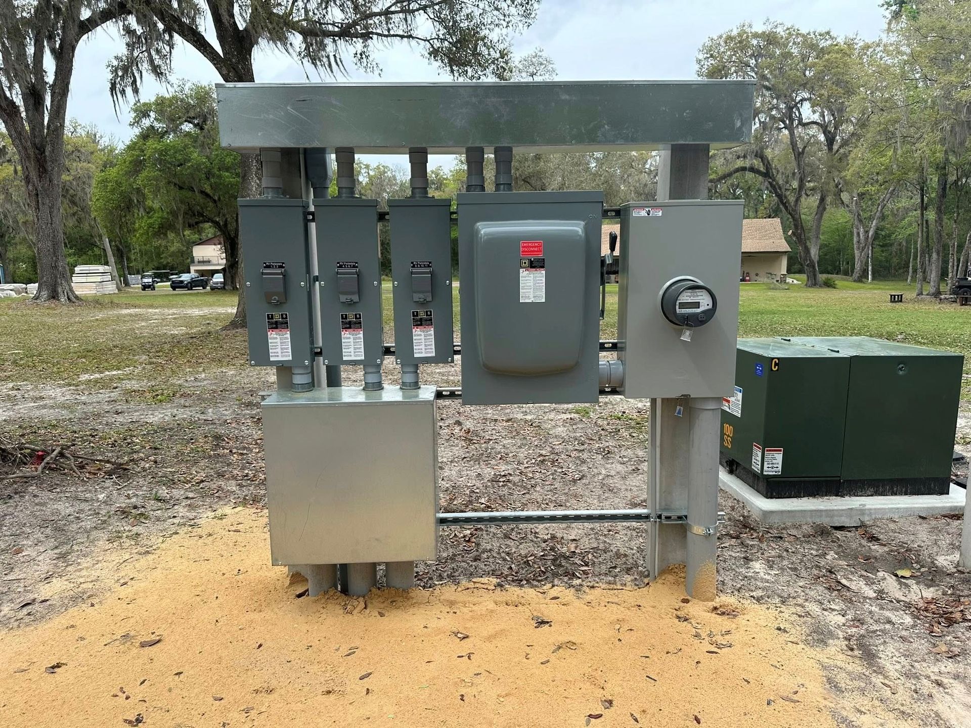 Outdoors electrical meter and breaker panel cluster on a metal stand in a wooded area