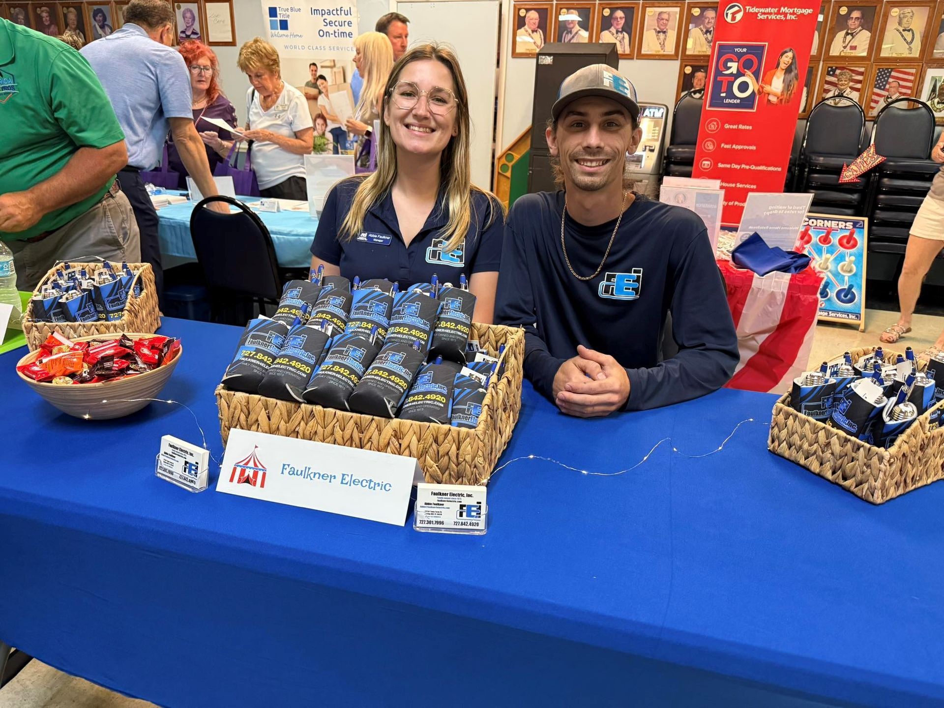 Two Faulkner Electric employees sitting at a trade booth to discuss the services and offerings of the company
