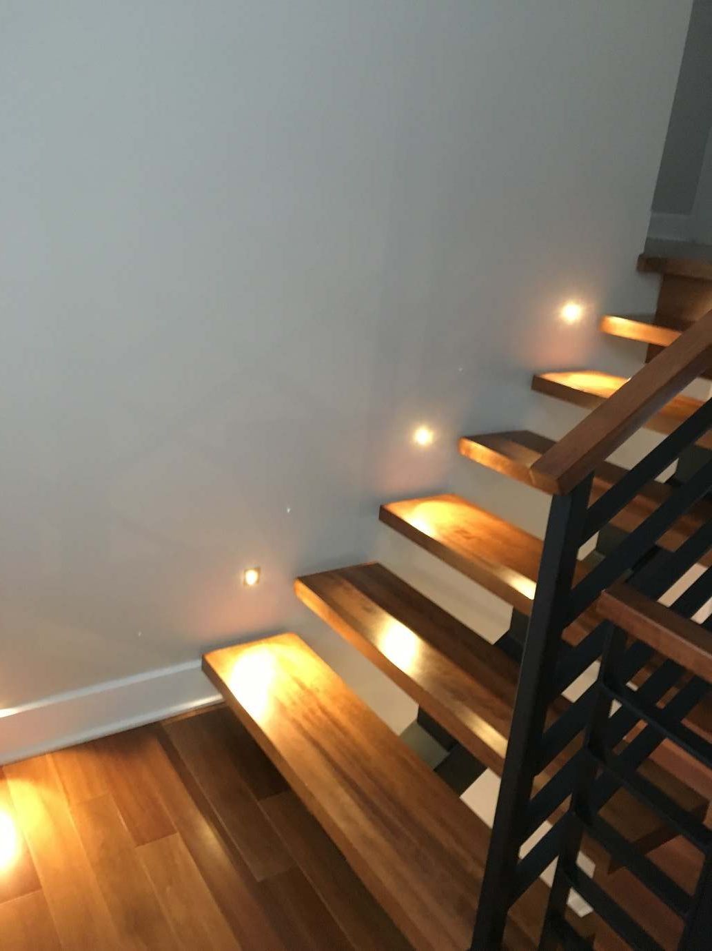 Un escalier en bois avec des lumières sur les marches