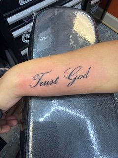 Forearm with a small black line tattoo of a dove holding an olive branch
