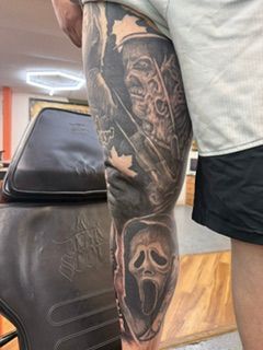 Close-up of a black-and-gray rose tattoo on a person’s upper arm and shoulder.
