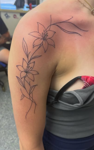 Black ink tattoo of two hands touching on a person’s upper arm