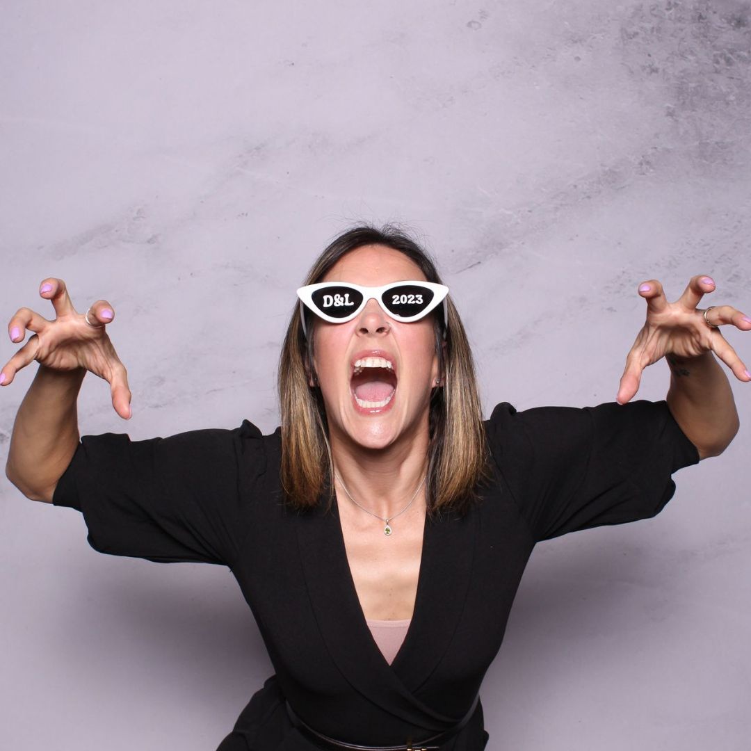 A woman wearing sunglasses has her mouth wide open
