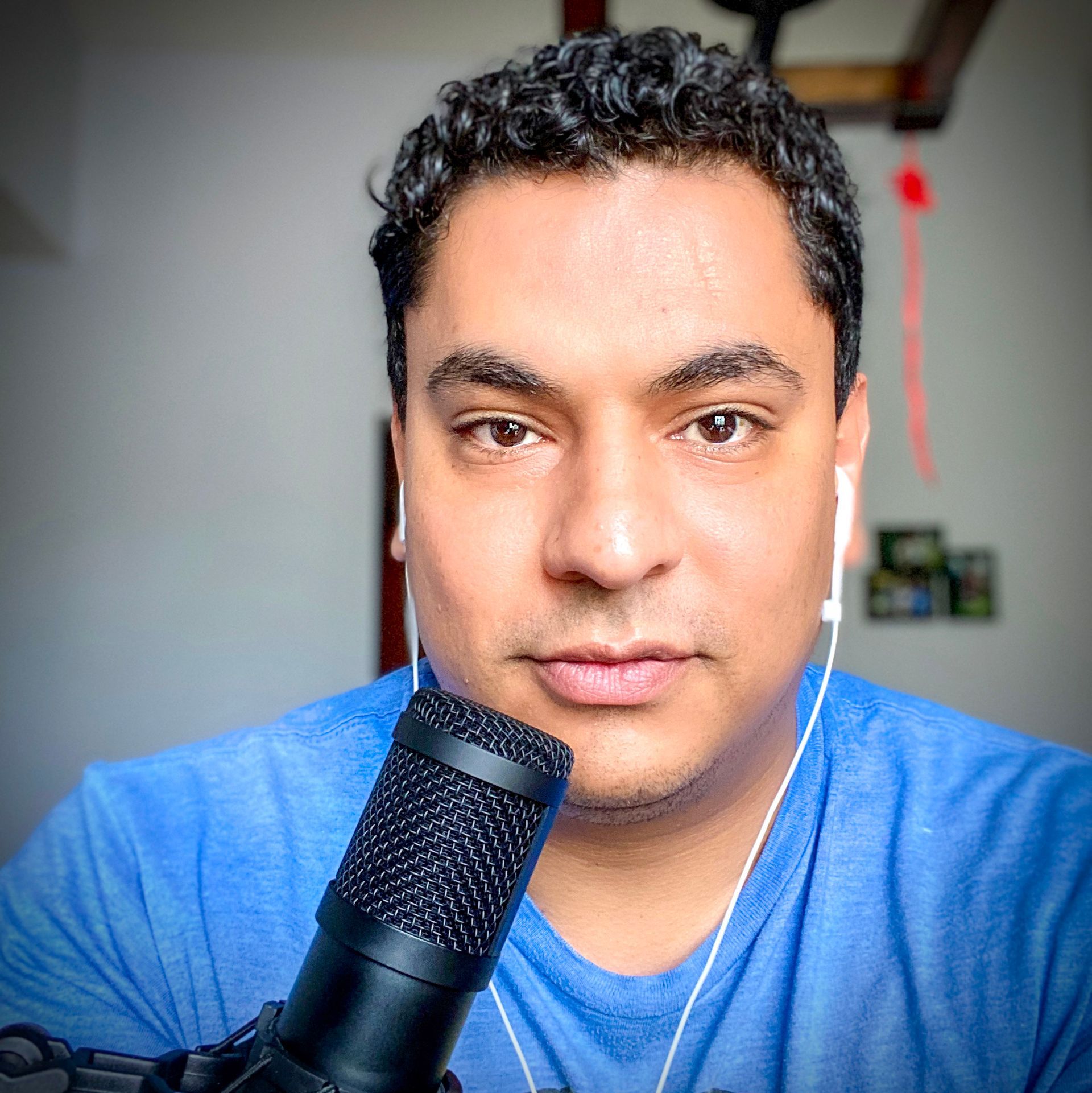 A man in a blue shirt is holding a microphone in front of his face.