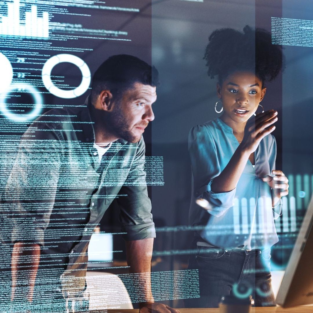 A man and a woman are looking at a computer screen.
