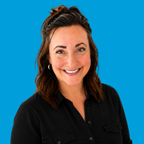 Smiling woman in a black shirt against a bright blue background