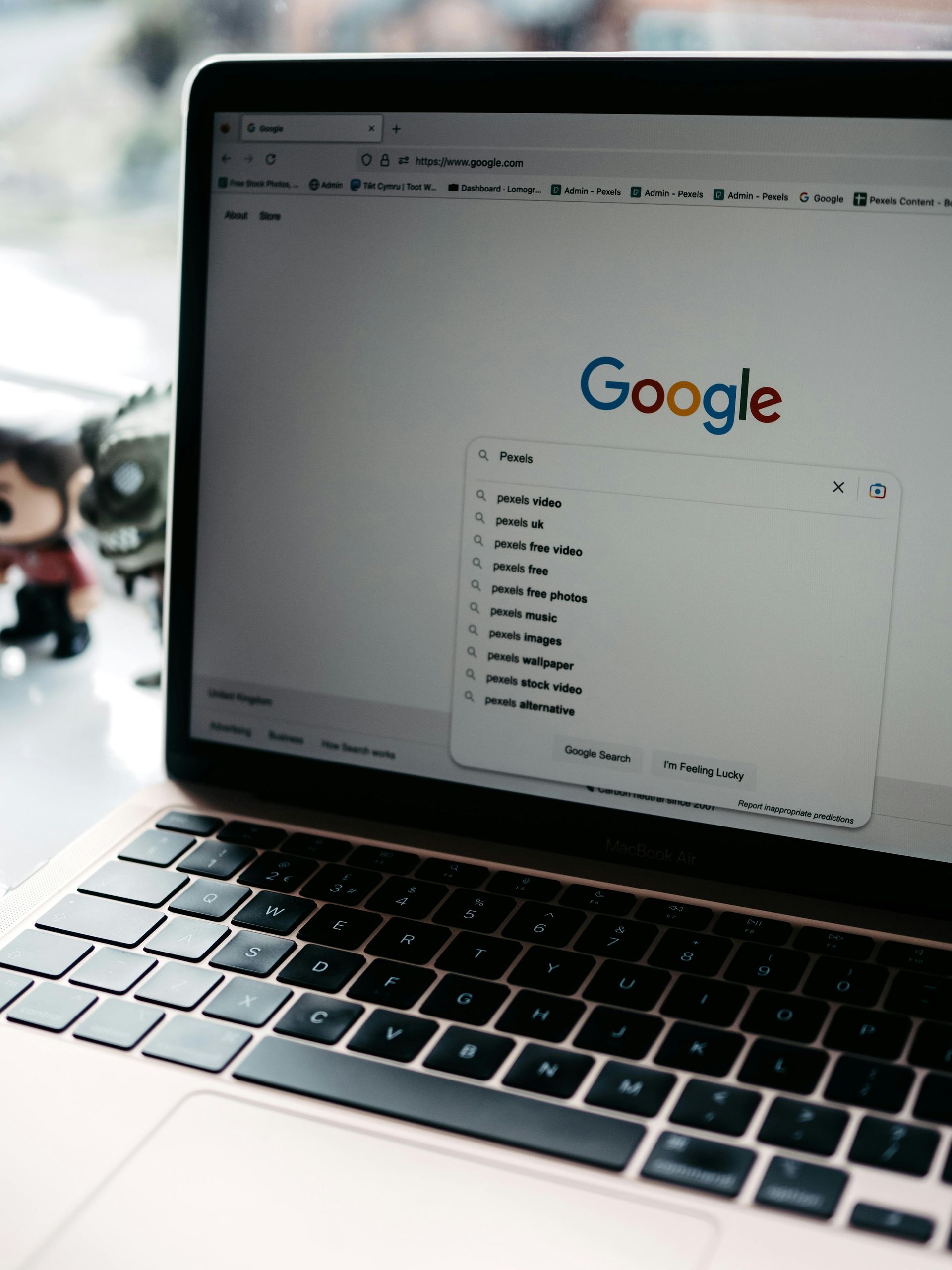 Laptop displaying Google search homepage with search suggestions open