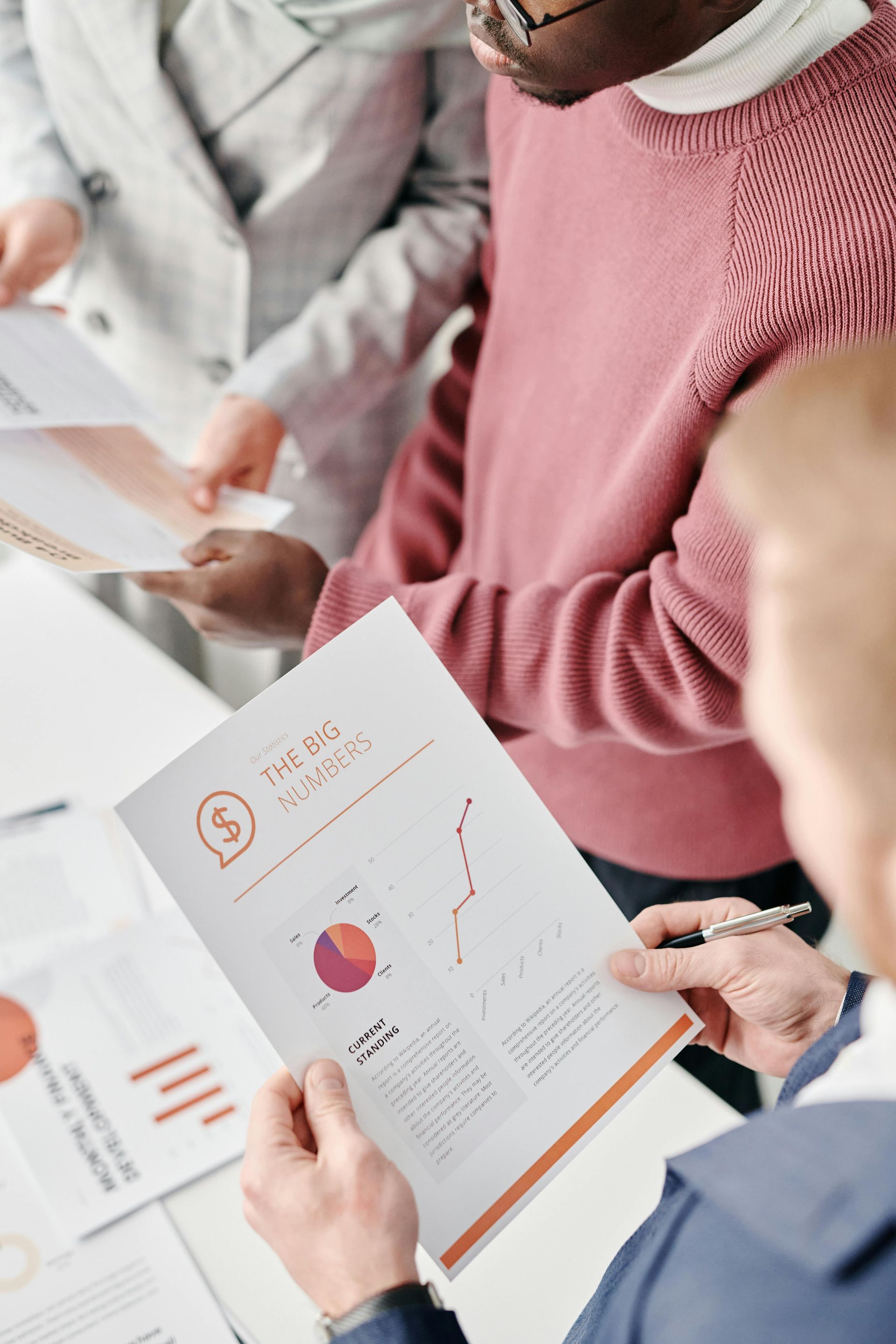People reviewing printed charts and graphs in a business meeting