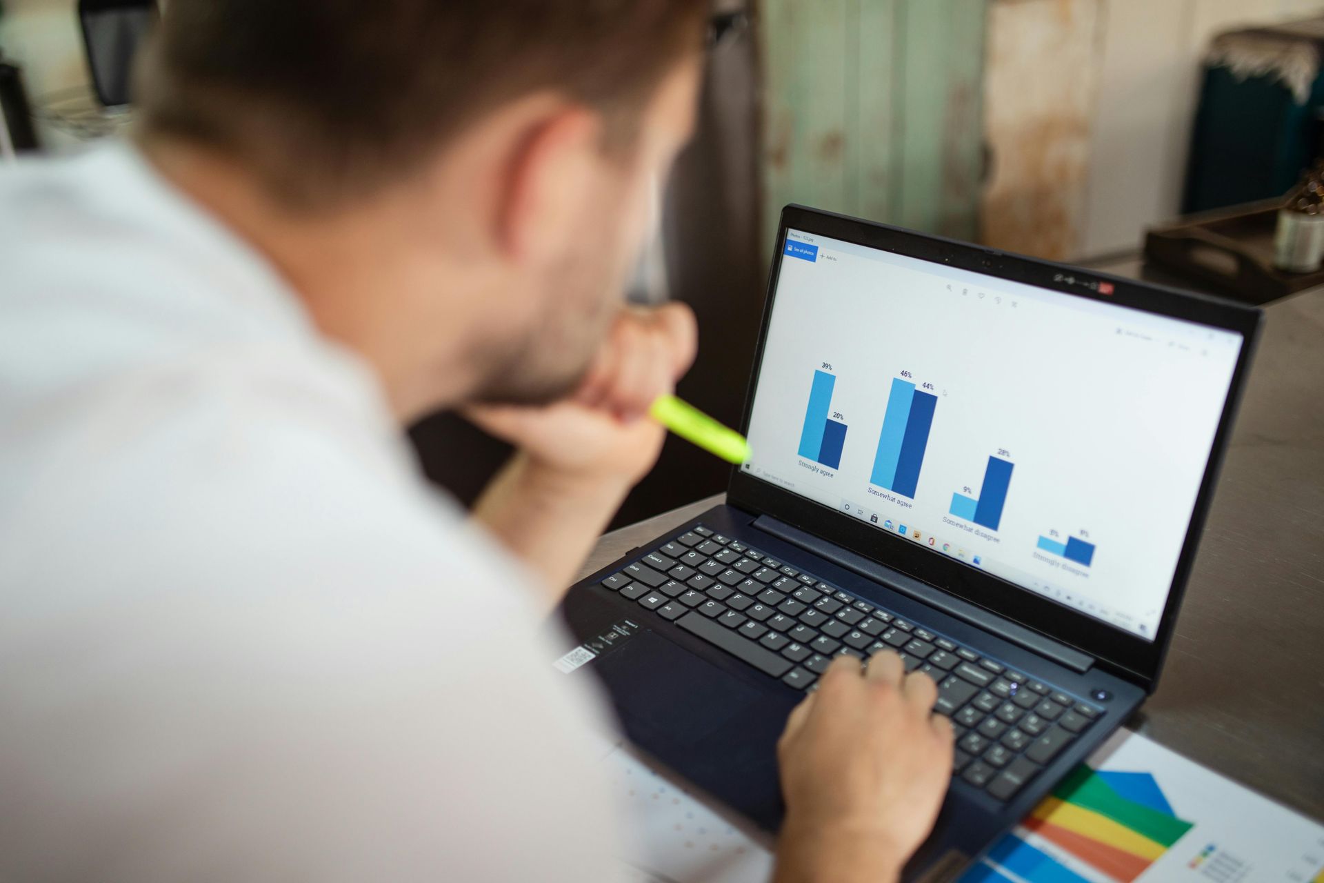 Person looking at laptop charts with a pencil in hand
