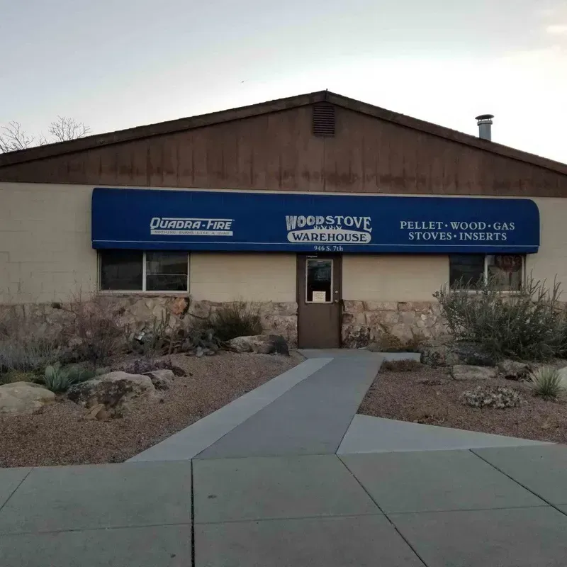 Front view of a commercial building with blue signage and a walkway through a desert-style landscape