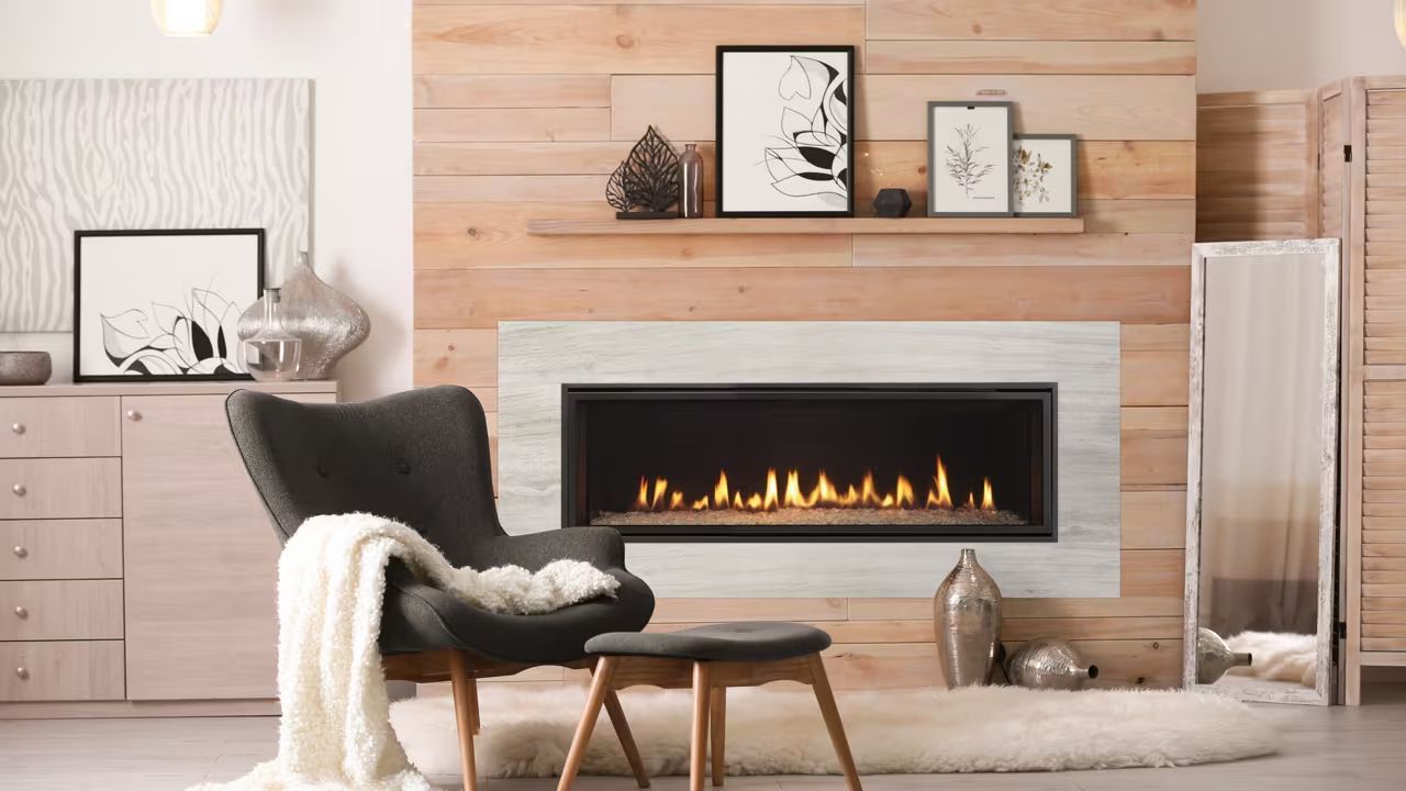 Modern bedroom with a black fireplace, two framed mirrors, and a neatly made bed
