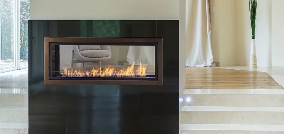 Modern white fireplace with a lit fire in a black surround and striped rug in front
