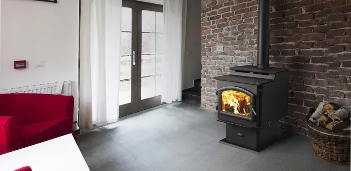 Woman reading beside a lit electric fireplace in a cozy living room