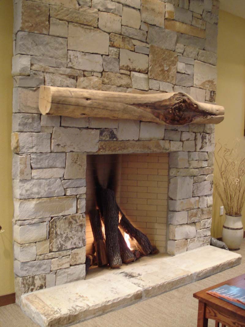 Woman reading by a lit electric fireplace in a cozy living room
