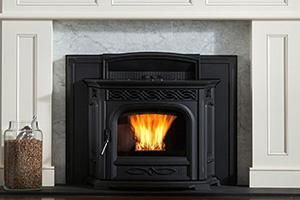 Black fireplace with a bright fire burning in a white mantel surround