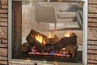 Modern fireplace with burning logs below a beige armchair and brick wall backdrop