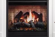 Gas fireplace with burning logs framed by a white mantel and black insert