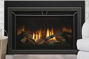 Modern black fireplace with burning logs and orange flames in a living room