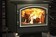 Black wood stove with bright orange flames burning inside