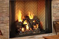 Lit fireplace with burning logs inside a brick and tile hearth