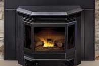 Black gas fireplace with glass doors and a small yellow flame burning inside.