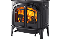 Black cast-iron wood stove with glass front, glowing fire visible inside