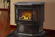 Black freestanding fireplace stove with a glowing fire in a room corner