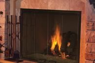 Lit fireplace with flames in a stone hearth