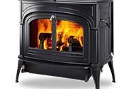 Black cast-iron wood-burning stove with a glass door and visible flames inside