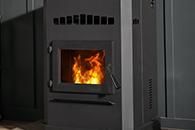 Black wood-burning stove with a visible orange fire burning inside.
