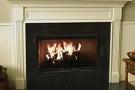 Lit fireplace with black surround and white mantel in a living room