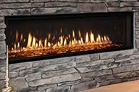 Modern linear fireplace with flames set in a gray stone wall