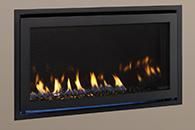 Modern black-framed gas fireplace with visible flames against a beige wall
