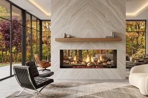 Modern living room with a long glass fireplace, chevron stone wall, and floor-to-ceiling windows overlooking autumn trees