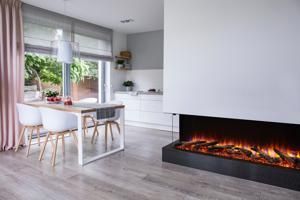 Modern open-plan dining area with white chairs, gray flooring, and a sleek electric fireplace