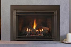 Modern fireplace with a small burning fire set into a gray wall.