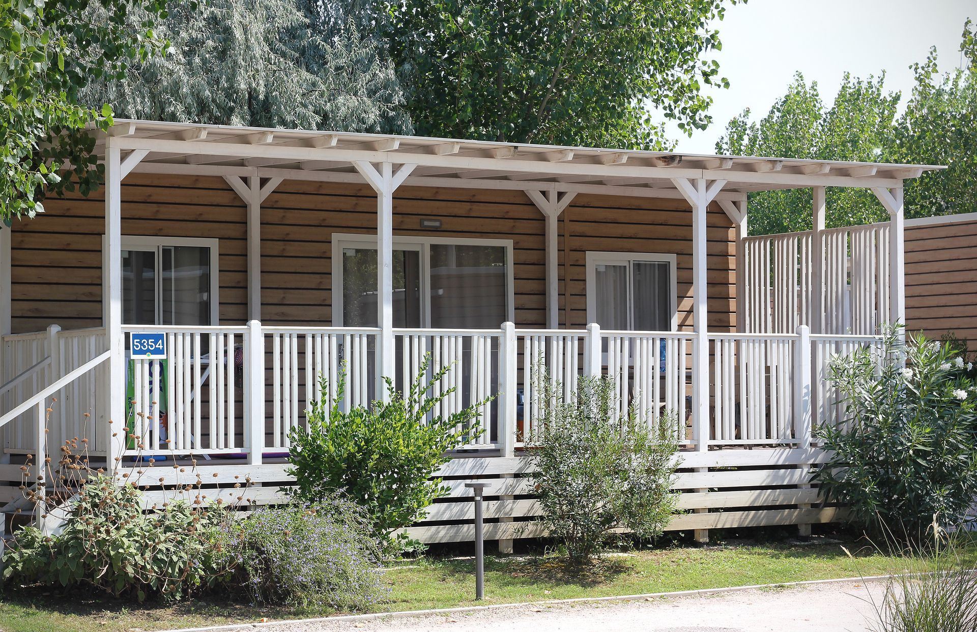 Manufactured home with covered wood deck and railing.