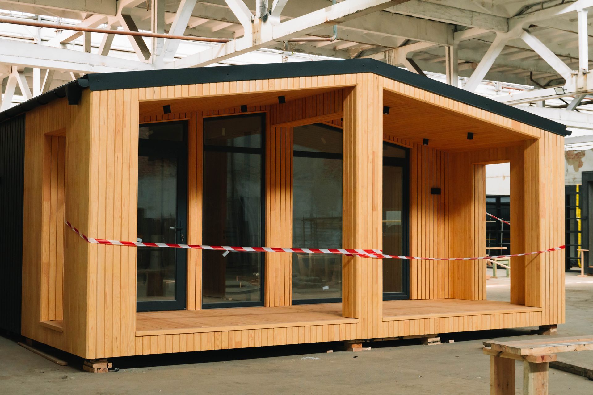 Modular manufactured home with wood siding and large windows on display at a mobile home parts shop