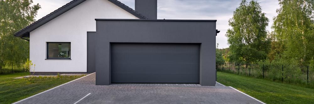 Modern House With a Gray Garage Door — Axcess Garage Doors in Yeppoon, QLD