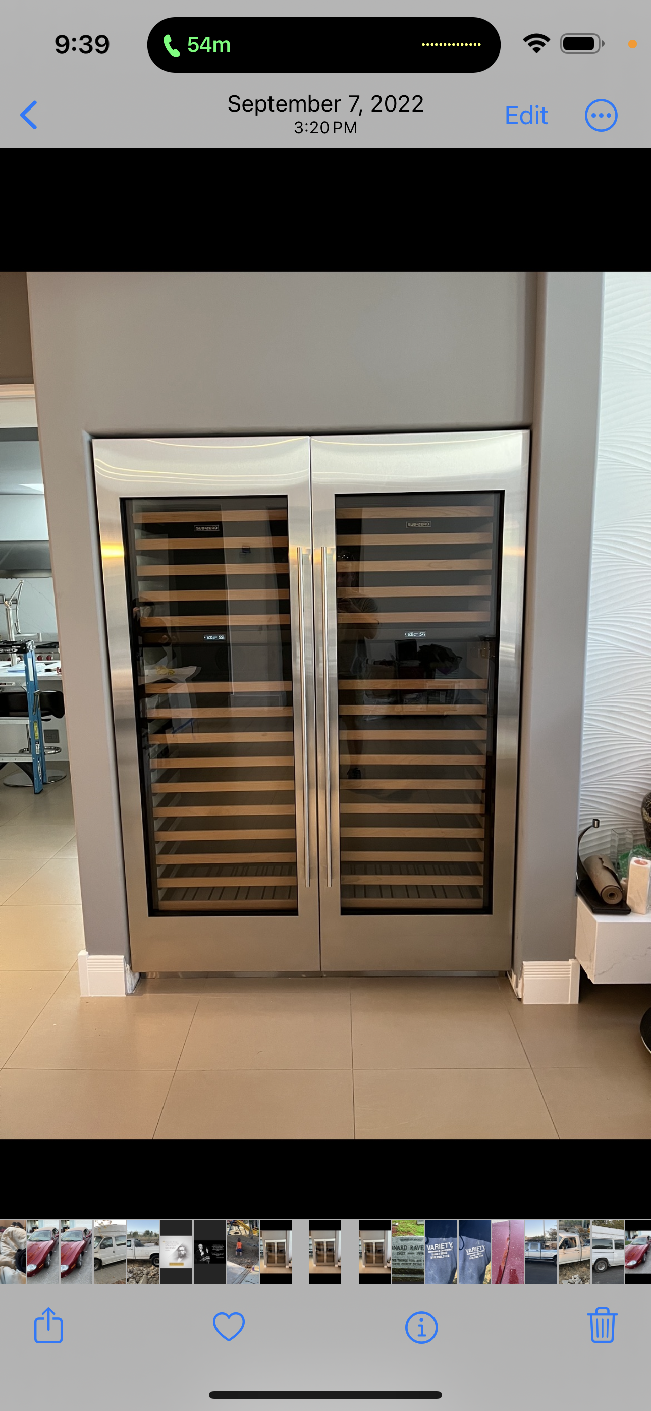 Stainless steel, double-door wine refrigerator built into a gray wall in a modern room with tiled flooring.